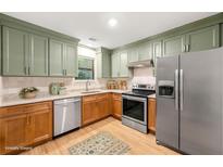 Charming kitchen features stainless steel appliances, two-tone cabinetry and a window view at 2300 Newport Lndg, Atlanta, GA 30009