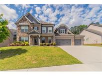 Beautiful two-story home with stone accents, three-car garage, and well-manicured lawn at 2910 Hampton Grove Trce, Dacula, GA 30019