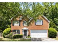 Charming two-story brick home featuring a well-maintained front yard and a two-car garage at 5404 Trumpet Vine Se Trl, Mableton, GA 30126