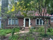 Charming brick home with a red tile roof and arched windows, surrounded by lush greenery at 1225 Cameron Ne Ct, Atlanta, GA 30306