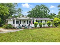Charming single-story home featuring a well-manicured lawn and an inviting front porch at 1430 Mineral Springs Rd, Hoschton, GA 30548