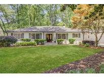 Charming traditional home with a manicured lawn, symmetrical landscaping, and a welcoming facade with many windows at 1343 Peachtree Battle Nw Ave, Atlanta, GA 30327