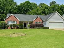 Charming brick home with well-maintained lawn and landscaping offering great curb appeal at 19 Windcrest Dr, Covington, GA 30016