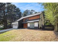 Modern two-story home with a dark roof, light wood accents, and an attached garage at 5346 Kelleys Mill Cir, Stone Mountain, GA 30088
