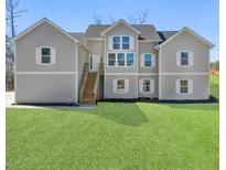 Inviting exterior elevation featuring a spacious front yard and a charming two-story design with a light gray exterior at 939 Whistler Ln, Canton, GA 30114