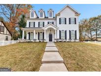 Elegant two-story white home featuring a well-manicured lawn and classic architectural details at 1898 Walker Ave, College Park, GA 30337