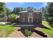 Charming two-story red brick home with symmetrical design, manicured lawn, and traditional architectural details at 227 Eton Ct, Mableton, GA 30126