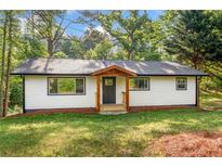 Charming ranch home featuring a new front porch and black trimmed windows, surrounded by mature trees at 474 Upper Burris Rd, Canton, GA 30114