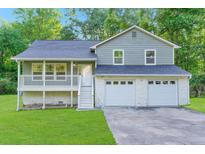 Charming split-level home with a two-car garage, front porch, and well-manicured lawn at 6625 Peppermill Ln, South Fulton, GA 30349