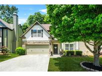 Charming home with a stone-accented facade, two-car garage, and a neatly landscaped front yard at 1326 Castleberry Dr, Buford, GA 30518