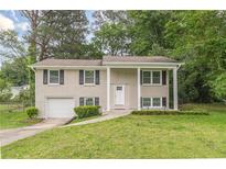 Charming two-story home featuring a well-maintained lawn and a classic brick facade with black shutters at 5312 Brittany Trl, Atlanta, GA 30349