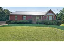 Charming home featuring a metal roof, well-maintained lawn, and mature landscaping at 999 Wiley Bridge Rd, Woodstock, GA 30188