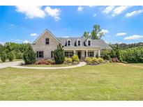 Charming brick home featuring a well-manicured lawn, mature trees, and a welcoming front porch at 122 Gingers Way, Mcdonough, GA 30252
