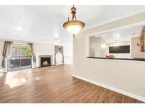 Bright living room featuring wood floors, a fireplace, and sliding glass doors leading to a balcony at 1482 N Crossing Ne Cir, Atlanta, GA 30329