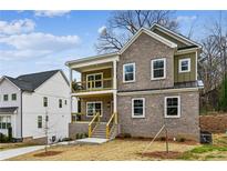 Charming two-story home features a brick facade, covered porch, and well-maintained landscaping at 3111 Stonegate Sw Dr, Atlanta, GA 30331