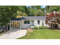 Charming brick home with a well-manicured lawn, a covered driveway and a quaint front garden at 962 Cardova Ne Dr, Atlanta, GA 30324