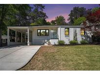 Charming home featuring a well-manicured lawn, covered car port, and freshly painted exterior at 962 Cardova Ne Dr, Atlanta, GA 30324
