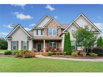 Charming two-story home with stone accents, manicured lawn, and a welcoming front porch at 161 Archstone Sq, Mcdonough, GA 30253