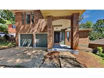 Charming two-story brick home featuring an attached two-car garage and a welcoming front entrance at 516 N Shore Rd, Lithonia, GA 30058