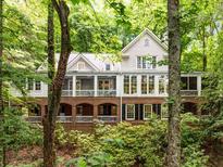 Stunning brick and grey home featuring a beautiful, private treed lot and a gracious, covered porch, offering an ideal retreat at 130 River Ne Lndg, Sandy Springs, GA 30350