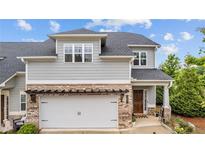 Charming two-story home with gray siding, brick accents, and a well-manicured lawn offers curb appeal at 4591 Grenadine Cir, Acworth, GA 30101