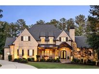 Stunning brick home featuring a beautifully landscaped front yard, elegant entrance, and meticulously maintained architecture at 670 Trinity Pl, Suwanee, GA 30024