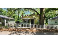Charming cottage-style home featuring a picket fence, covered porch, and mature trees at 1162 Sims St, Atlanta, GA 30310