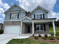 Charming two-story home featuring a brick and siding exterior with black shutters, a covered entrance and a two-car garage at 3064 Steinbeck Way, Atlanta, GA 30344