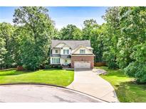 Charming two-story home with brick and siding, set back on a lovely landscaped lot surrounded by mature trees at 596 Deadwood Trl, Locust Grove, GA 30248