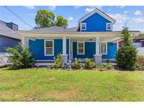 Charming two-story home with a blue exterior, inviting front porch, and well-manicured lawn at 1598 Jonesboro Se Rd, Atlanta, GA 30315