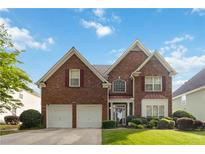 Charming two-story brick home boasts a well-manicured lawn, attached two car garage, and inviting curb appeal at 7325 Thoreau Cir, Atlanta, GA 30349