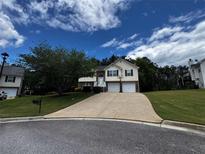 Inviting two-story home features a spacious driveway, manicured lawn, and charming architectural details at 851 Walkingstick Dr, Douglasville, GA 30134