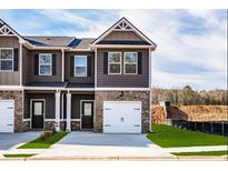 Beautiful townhome featuring a brick facade, a single-car garage and a well manicured lawn at 231 Ivey Ter, Temple, GA 30179