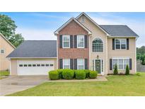 Charming two-story home with a brick facade, lush lawn and well-maintained landscaping at 2586 Abbotts Glen Nw Dr, Acworth, GA 30101