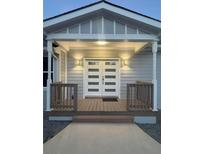 Inviting front entrance featuring double doors, a covered porch, and decorative lighting creating a warm and welcoming ambiance at 9058 Woodlake Lane, Villa Rica, GA 30180