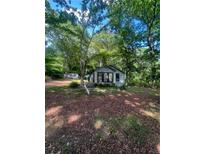 View of the home's exterior, showing the yard and surrounding mature trees at 2700 Snapfinger Rd, Decatur, GA 30034