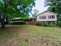 Traditional home with a manicured front yard and a mix of brick and siding exterior at 3026 Hidden Forest Dr, Snellville, GA 30078