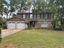 Two-story home with stone and siding, two-car garage, and a well-manicured front lawn at 1055 Worthington Hills Dr, Roswell, GA 30076
