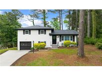 Charming white brick home with a well-manicured lawn and an attached garage at 1934 Glen Echo Dr, Decatur, GA 30032