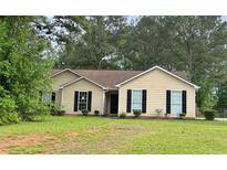 Charming single-story home featuring manicured lawn and classic curb appeal with mature trees at 432 Manor Estates Dr, Stockbridge, GA 30281