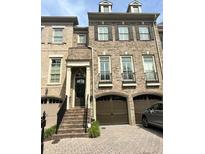Charming brick townhome with front-entry garage and well-maintained landscaping at 9056 Riverbend Mnr, Alpharetta, GA 30022