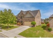 Beautiful two-story brick home with a well-manicured lawn, landscaping and attached two car garage at 3039 Tuscan Ridge Dr, Snellville, GA 30039