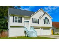 Charming two-story home featuring a well-maintained lawn, a two-car garage, and eye-catching white siding with black shutters at 5683 Isleworth Way, Atlanta, GA 30349