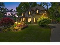 Charming home featuring a landscaped front yard and inviting curb appeal with a brick facade at 5725 Lake Oak Lndg, Cumming, GA 30040