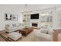 Bright living room boasts a fireplace, large windows with shutters, and stylish decor at 5725 Lake Oak Lndg, Cumming, GA 30040