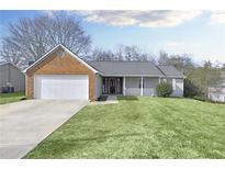 Charming single Gathering home featuring an attached two car garage and well-manicured front lawn at 6057 Dorchester Dr, Rex, GA 30273