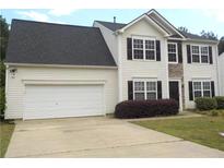 Charming two-story home with a two-car garage and well-maintained lawn and stone accents around front entry at 1371 Blazing Star Rd, Lawrenceville, GA 30045