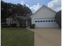 Charming single-story home featuring a well-manicured lawn, two-car garage, and classic suburban appeal at 282 Ellesmere Court, Buford, GA 30518