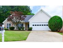 Charming home with a well-maintained lawn, mature landscaping, and a two-car garage at 282 Ellesmere Court, Buford, GA 30518