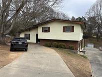 Split level home showcasing a long driveway leading up to the two-story house with brick and siding at 2195 Wilson Rd, Conyers, GA 30012